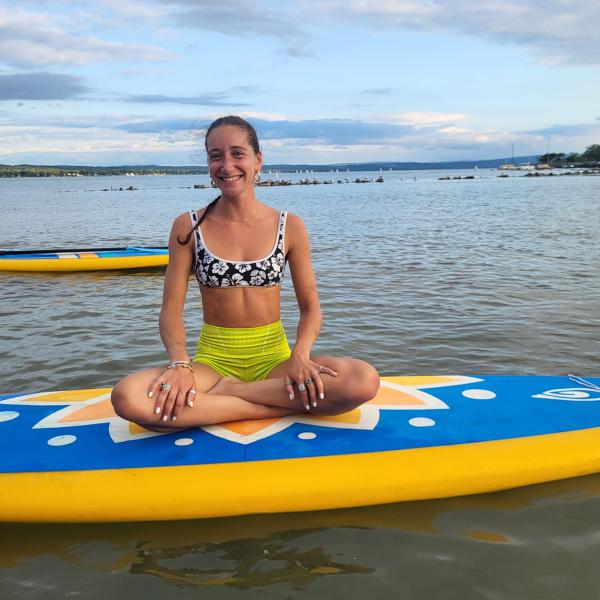 SUP Yoga participant relaxes on paddleboard