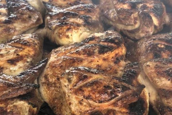 close up of chicken breasts in rows on grill