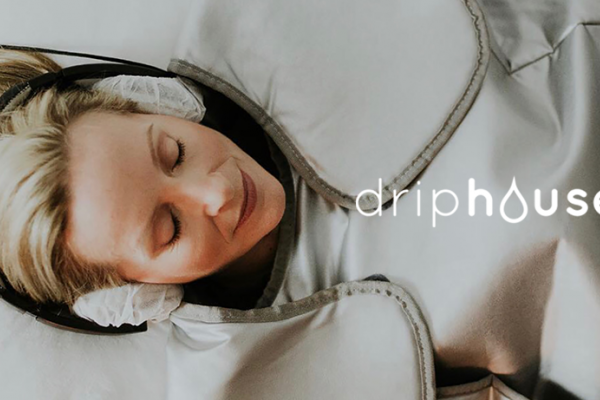 woman laying down wrapped up with headphones, drip house logo overlay on the photo