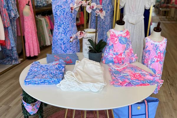 Interior image of retail store, featuring women's clothing in primarily blue and pink