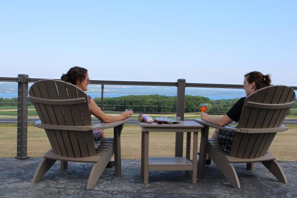 two people sitting in adirondack chairs looking at the view