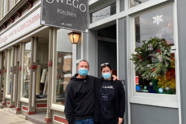 Owners of Owego kitchen in front of restaurant.