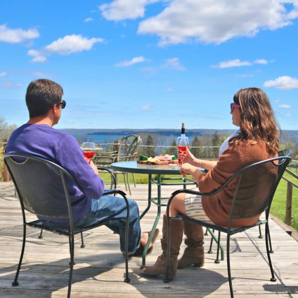 couple enjoying wine and food on the deck at Buttonwood Grove