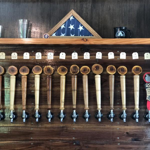 No BS Brewery beer tap handles with a flag folded in a case above the taps