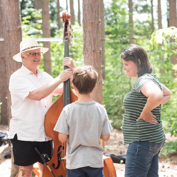 Musician shows child and mother his instrument.