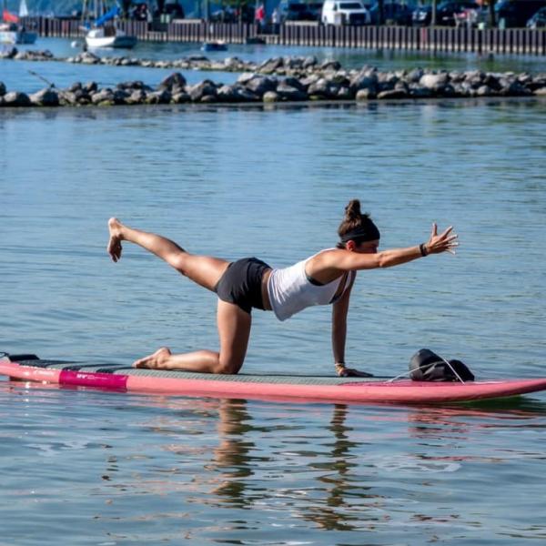 SUP Yoga Class - Woman does bird dog pose